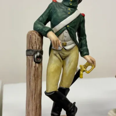 Vintage porcelain figurine of a French Napoleonic soldier labeled 'Dragon 1805', depicting a soldier in a green uniform leaning...