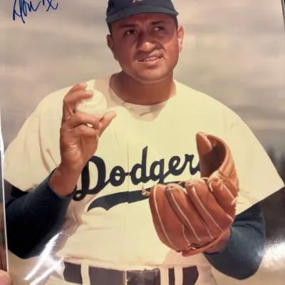 Autographed color photograph of Brooklyn Dodgers pitcher Don Newcombe, signed in blue ink in the upper left corner.