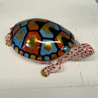 Herend porcelain turtle figurine featuring a hand-painted red fishnet pattern on the body and a colorful, gilded geometric shell.