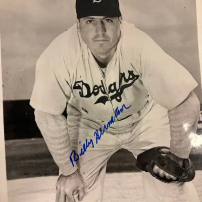Autographed black and white photograph of Hall of Fame baseball player Billy Herman in a Brooklyn Dodgers uniform.
