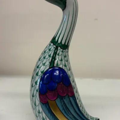 Herend porcelain duck figurine featuring a hand-painted green fishnet pattern, colorful wings, and gold accents on the beak and eyes.