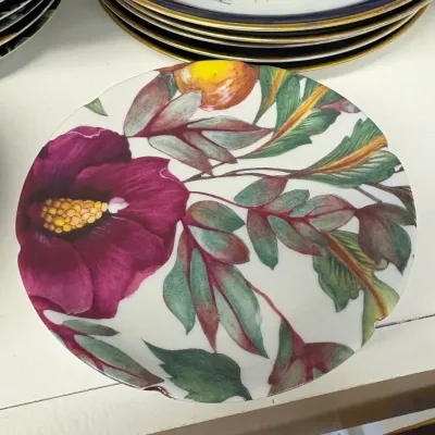 Vintage ceramic Limoges plate featuring a vibrant hand-painted design of a purple hibiscus flower, green leaves, and a yellow fruit.