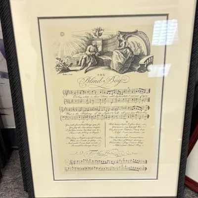 Framed vintage print of "The Blind Boy" sheet music, featuring an illustrated classical scene, double-matted in a dark textured...
