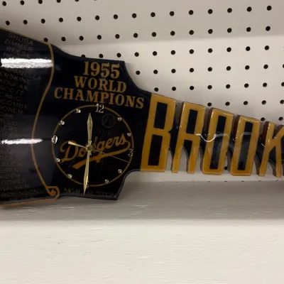 Vintage 1955 Brooklyn Dodgers World Champions commemorative wall clock, shaped like a pennant with a roster of players listed on the left.