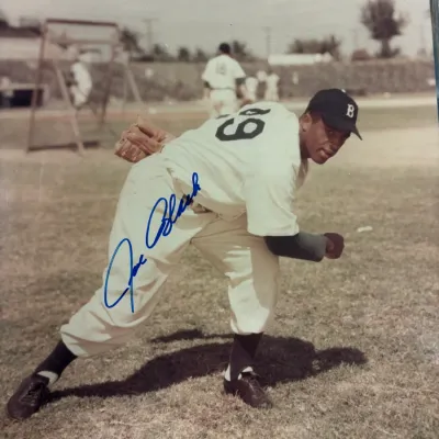 Autographed color photograph of Brooklyn Dodgers pitcher Joe Black in a pitching pose, signed in blue ink.