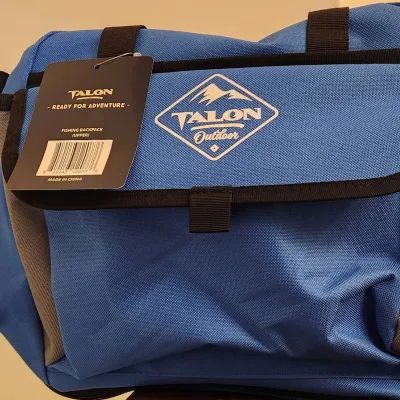 Sale Photo Thumbnail #345: Talon Outdoor Fishing Backpack (Upper) in a vibrant blue and grey color. Versatile outdoor bag features a durable canvas-like construction with a water-resistant interior lining, Includes a large main zippered compartment, a front hook-and-loop flap pocke