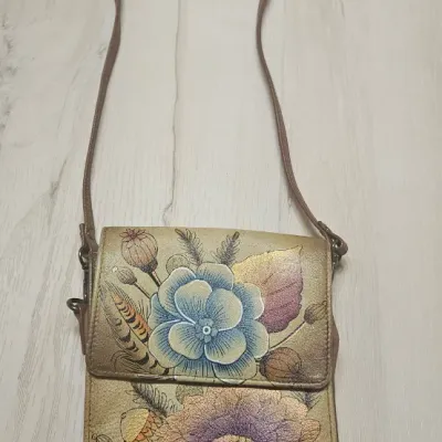 Sale Photo Thumbnail #87: Expertly crafted from genuine top grain leather, it features an accordion-style layout with RFID protection and multiple compartments, perfect for everyday use or travel. Length: 5.25" Width: 4" Height: 6" Adjustable Strap Drop: 13"to 26"