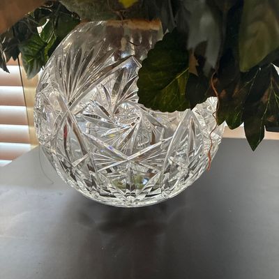 Sale Photo Thumbnail #540: Floral arrangement featuring faux burgundy and peach peonies, magnolias, and greenery set in a round cut crystal/glass rose bowl vase. Overall good condition with no visible chips or cracks to the glass.
