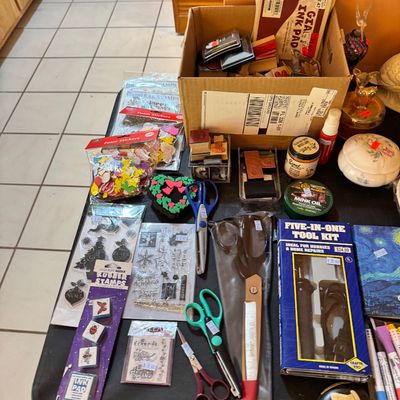 Assortment of crafting supplies including rubber stamps, ink pads, foam stickers, scissors, and a five-in-one tool kit.