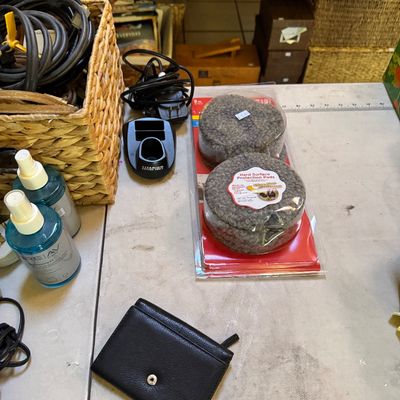 Assorted household items including a black leather wallet, a package of hard surface protection pads, cleaning spray bottles, and a...