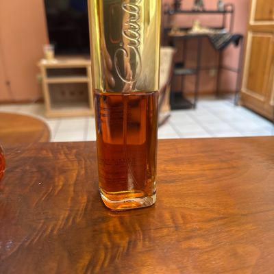Vintage Ciara by Charles Revson concentrated cologne spray bottle, partially filled, featuring its signature tall gold-tone cap.