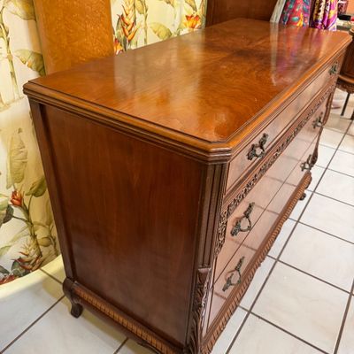 Vintage mahogany three-drawer dresser featuring ornate carved details, brass drop-pull hardware, and a polished wood finish.