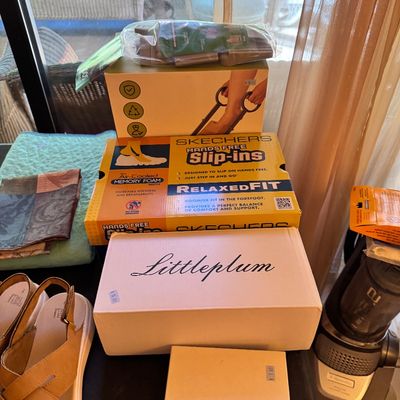 Assorted footwear and household items, including a pair of tan strappy sandals, a Skechers Hands Free Slip-ins shoe box, and a Littleplum...