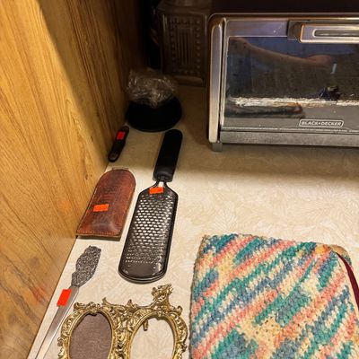 Assorted kitchen and home decor items including a Black & Decker toaster oven, a Microplane-style grater, a small ornate brass double...