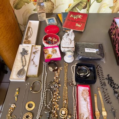 Assortment of vintage costume jewelry, watches, and small collectibles, including necklaces, brooches, a nativity figurine, and...