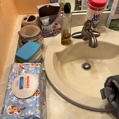 Assorted personal care and household items, including Huggies baby wipes, Neutrogena liquid soap, and Wet Ones wipes, arranged on a...