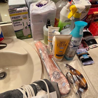 Assorted personal care and household items, including hair accessories, Neutrogena cleanser, Equate saline enemas, and cleaning sprays,...