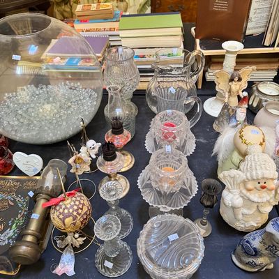 Assortment of vintage glassware and holiday decor, including cut-glass candle holders, a large fishbowl filled with glass marbles,...
