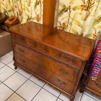 Vintage French Provincial style three-drawer dresser featuring burl wood veneer, ornate carved details, and brass hardware.