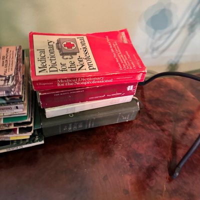Stack of vintage reference books, featuring a red paperback copy of "Medical Dictionary for the Nonprofessional" by Charles F....
