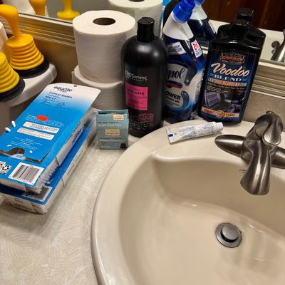 Assorted household items including toilet paper, TRESemmé shampoo, Lysol toilet bowl cleaner, Voodoo Blend leather rejuvenator, and...