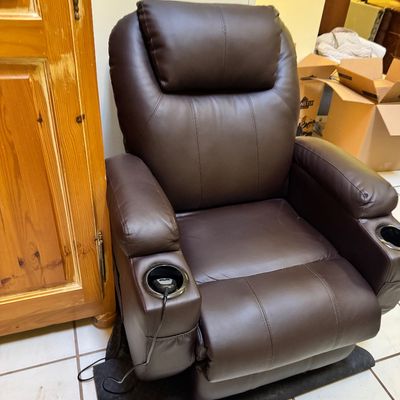 Modern brown faux-leather power recliner featuring built-in cup holders and a wired remote control.