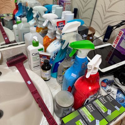 Assortment of household cleaning sprays, personal care items, and toiletries, including Dove Men+Care soap bars and CeraVe facial...