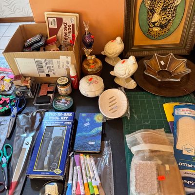 Assortment of craft supplies, tools, and home decor items, including rubber stamps, scissors, a five-in-one tool kit, ceramic bird...