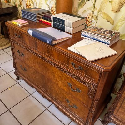 Vintage French Provincial style burl wood dresser featuring ornate carved details, brass hardware, and cabriole feet, topped with various...