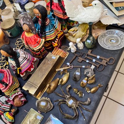 Assortment of vintage collectibles including handmade yarn-hair dolls in traditional dress, brass animal figurines, large skeleton keys,...