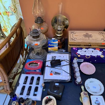 Assorted household items including vintage oil lamps, essential oils, a Toastmaster timer, small decorative dishes, and a wooden box...