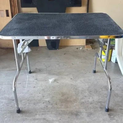 Portable folding pet grooming table with a non-slip textured top
