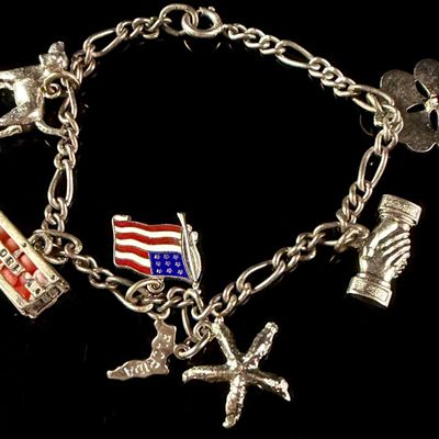 Sale Photo Thumbnail #92: A Vintage Sterling Silver Figaro Link Charm Bracelet Featuring Wells and Travel Themed Charms