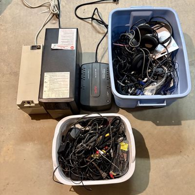 Sale Photo Thumbnail #346: Assortment of APC and Tripp Lite Uninterruptible Power Supplies with Peripheral Cables and Headphones