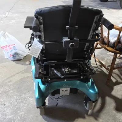 Older Solaire motorized power wheelchair with owner's manual and accessories