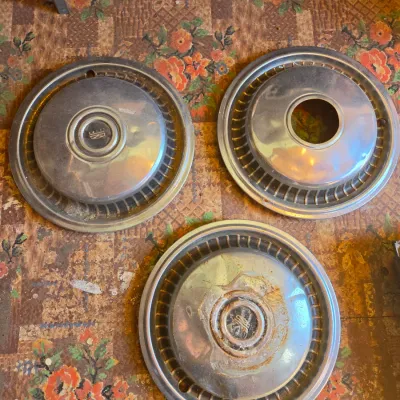 Three vintage chrome hubcaps
