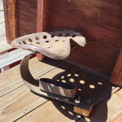 Two rustic tractor seats with seat attachment