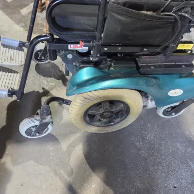 Older Solaire motorized power wheelchair with owner's manual and accessories