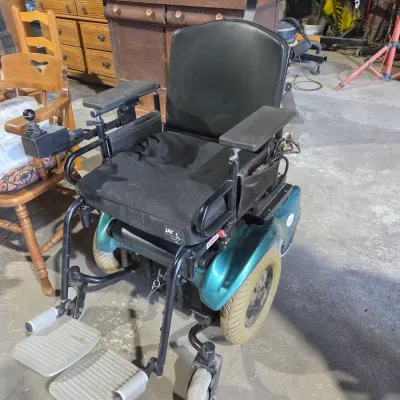 Older Solaire motorized power wheelchair with owner's manual and accessories