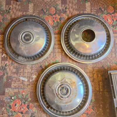 Three vintage chrome hubcaps