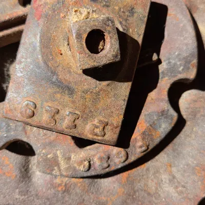 Two vintage steel tractor seats - one partially green