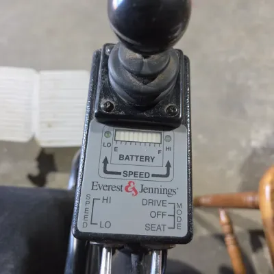 Older Solaire motorized power wheelchair with owner's manual and accessories