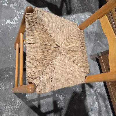 Vintage light wood ladder-back chair with a traditional woven rush seat
