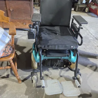 Older Solaire motorized power wheelchair with owner's manual and accessories