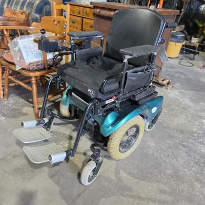 Older Solaire motorized power wheelchair with owner's manual and accessories