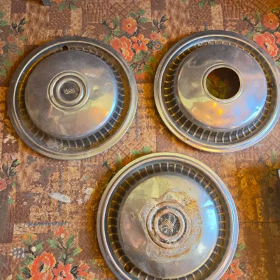 Three vintage chrome hubcaps