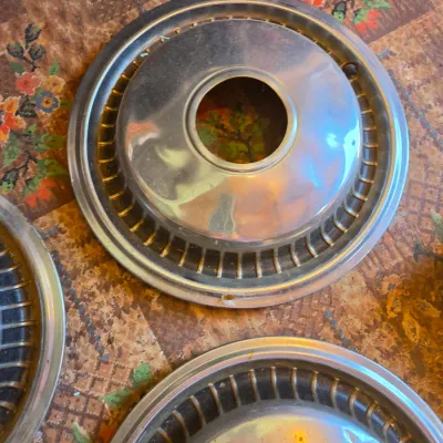 Three vintage chrome hubcaps