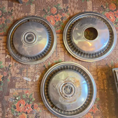 Three vintage chrome hubcaps