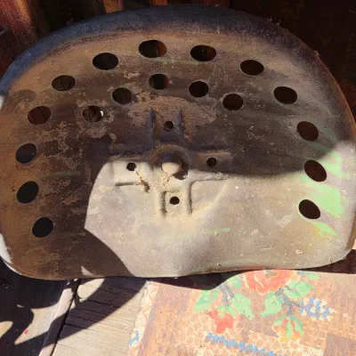 Two vintage steel tractor seats - one partially green