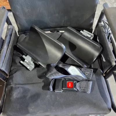 Older Solaire motorized power wheelchair with owner's manual and accessories